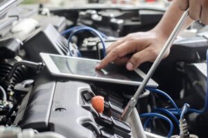 Hands of car mechanic in auto repair service.