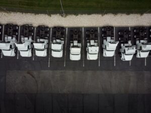 Fleet of white 18-wheeler semi-trucks overhead view drone photog