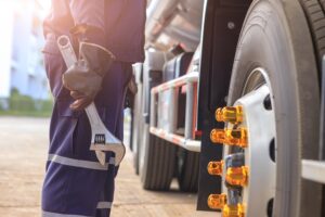 Mechanic with Large Wrench in Hand Taking Look at on the Truck,C