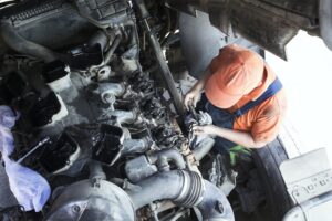 Mechanic repairs a truck. adjustment of valves of the diesel mo