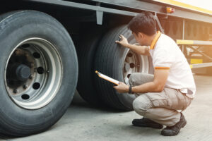 Truck driver holding clipboard inspecting safety check a truck tires, vehicle maintenance checklist a semi truck