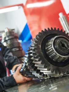 Truck repair service. serviceman works gear shaft of gearbox